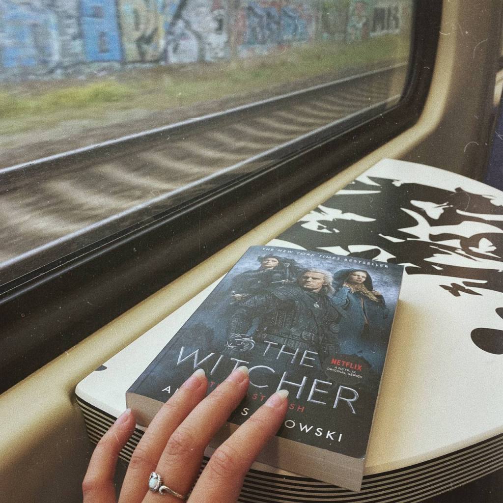 Het boek the last wish Witcher Andrzej sapkowski op een tafeltje in de trein