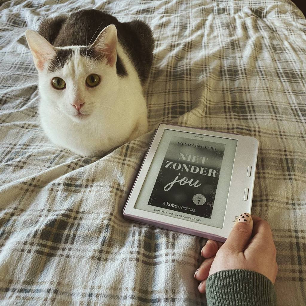 Ik houd mijn e-reader met daarop het omslag van Niet zonder jou van Wendy Brokers vast naast mijn kat Alfie die in de camera kijkt.